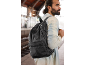Homem com mochila numa estação de comboios.
