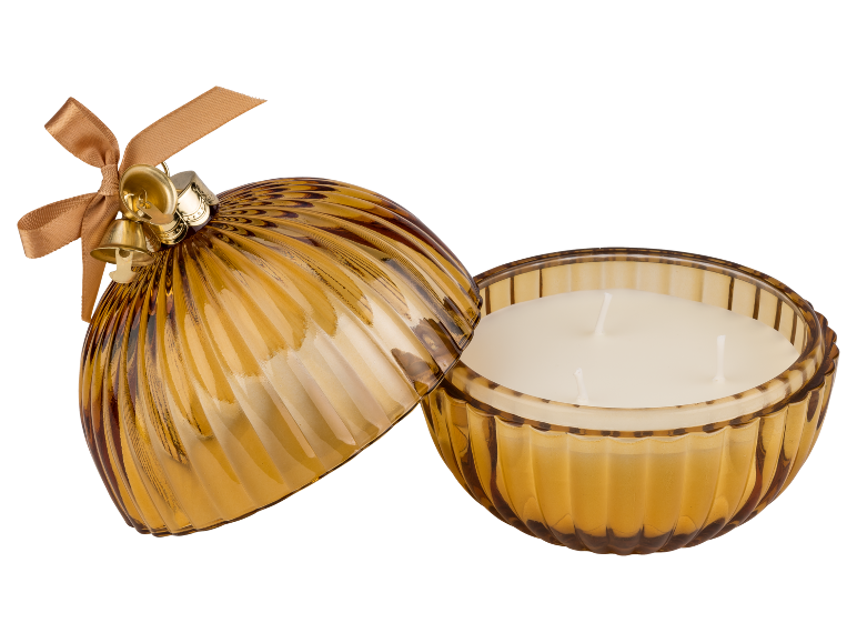 Vela perfumada em recipiente de vidro âmbar com tampa decorada com laço e sinos.