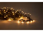Grinalda de luzes de Natal com luzes quentes e cintilantes em ramos de pinheiro.