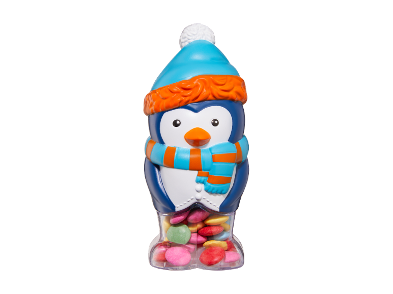 Dispensador de doces de pinguim com gorro e cachecol, cheio de rebuçados coloridos.