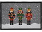 Capacho de Natal com três quebra-nozes coloridos sobre um fundo nevado.