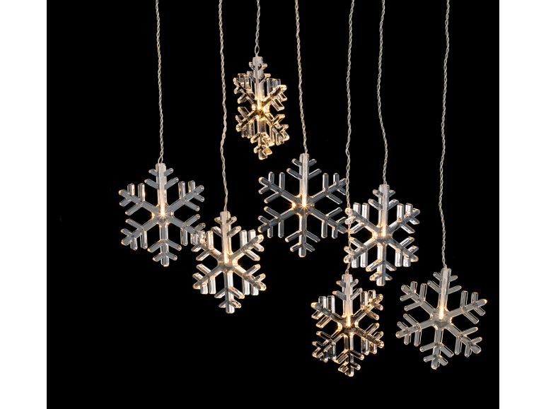 Decorações luminosas de Natal em forma de flocos de neve sobre fundo preto.