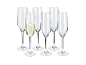 Seis flutes de champanhe, um cheio de vinho espumante, sobre fundo preto.