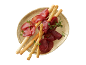 Bresaola com grissini e tomilho num prato dourado