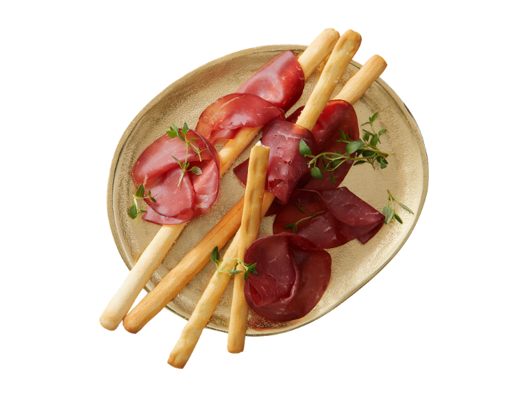 Bresaola com grissini e tomilho num prato dourado