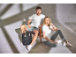 Homem e mulher com t-shirts brancas e calções/leggings, com uma mochila ao lado.