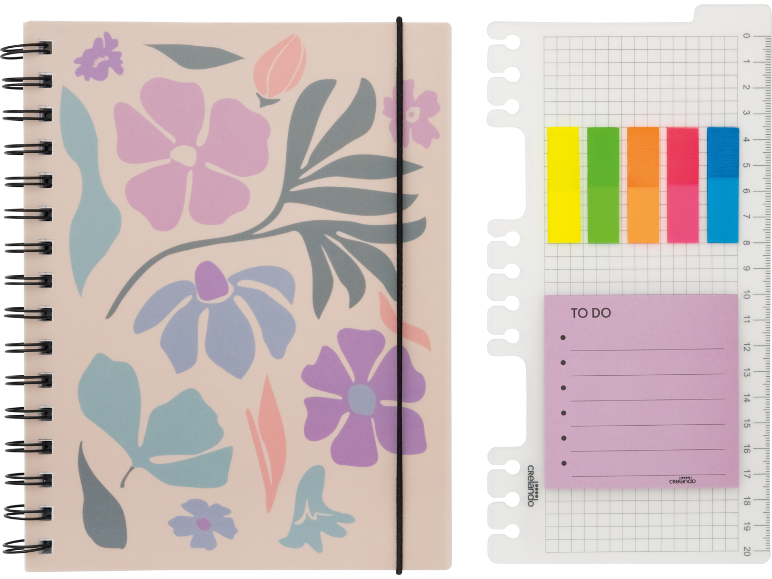 Um caderno em espiral com padrão floral e elástico, ao lado de uma régua com notas adesivas.