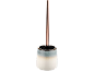 Escova de sanita com suporte cerâmico branco e azul-esverdeado, e cabo cor de cobre.