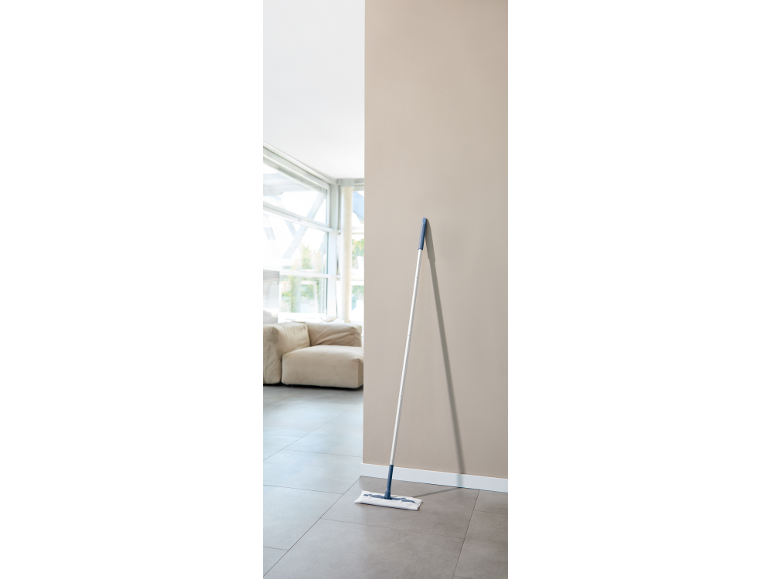 Mopa de chão encostada a uma parede numa sala de estar moderna.