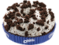 Bolo de chocolate com cobertura branca e pedaços de biscoito esfarelados numa forma azul.