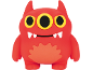 Brinquedo de monstro vermelho com três olhos amarelos e presas brancas.