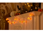 Decorações de Halloween com abóboras luminosas, um esqueleto e fantasmas de papel.