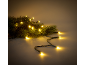 Luzes de Natal com brilho amarelo quente entrelaçadas com ramos de pinheiro verde.