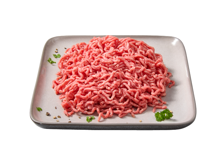 Carne picada crua num prato cinzento com especiarias e salsa.