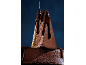 Bolo de chocolate com calda de chocolate escuro, com uma fatia cortada.