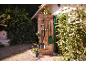 Ferramentas de jardinagem penduradas numa porta de madeira, com uma pá e um ancinho em primeiro plano.