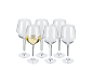 Seis copos de vinho, um cheio de vinho branco, sobre fundo preto.
