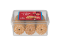 Recipiente de plástico transparente com biscoitos de coco em anel e um rótulo vermelho com ícones de Natal.