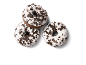 Três donuts de chocolate com cobertura branca e pedaços de bolacha.