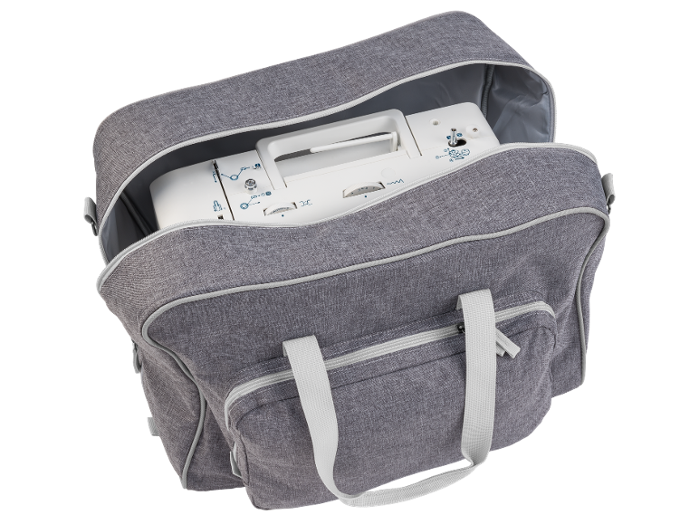 Saco cinzento para máquina de costura com fecho aberto, contendo uma máquina de costura branca