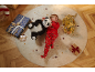 Menino de pijama vermelho com panda e tigre de pelúcia, rodeado por presentes de Natal.