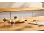 Café em copos de parede dupla e biscoitos numa bancada de madeira.