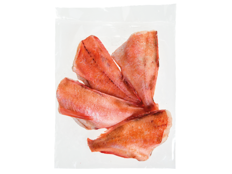 Quatro pedaços de peixe vermelho em embalagem a vácuo transparente.