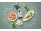 Queijo Grana Padano Riserva, carpaccio de tomate e massa com pesto, decorados com luzes de Natal.