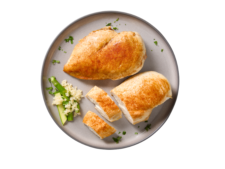 Peito de frango assado com cuscuz e vegetais num prato cinzento.