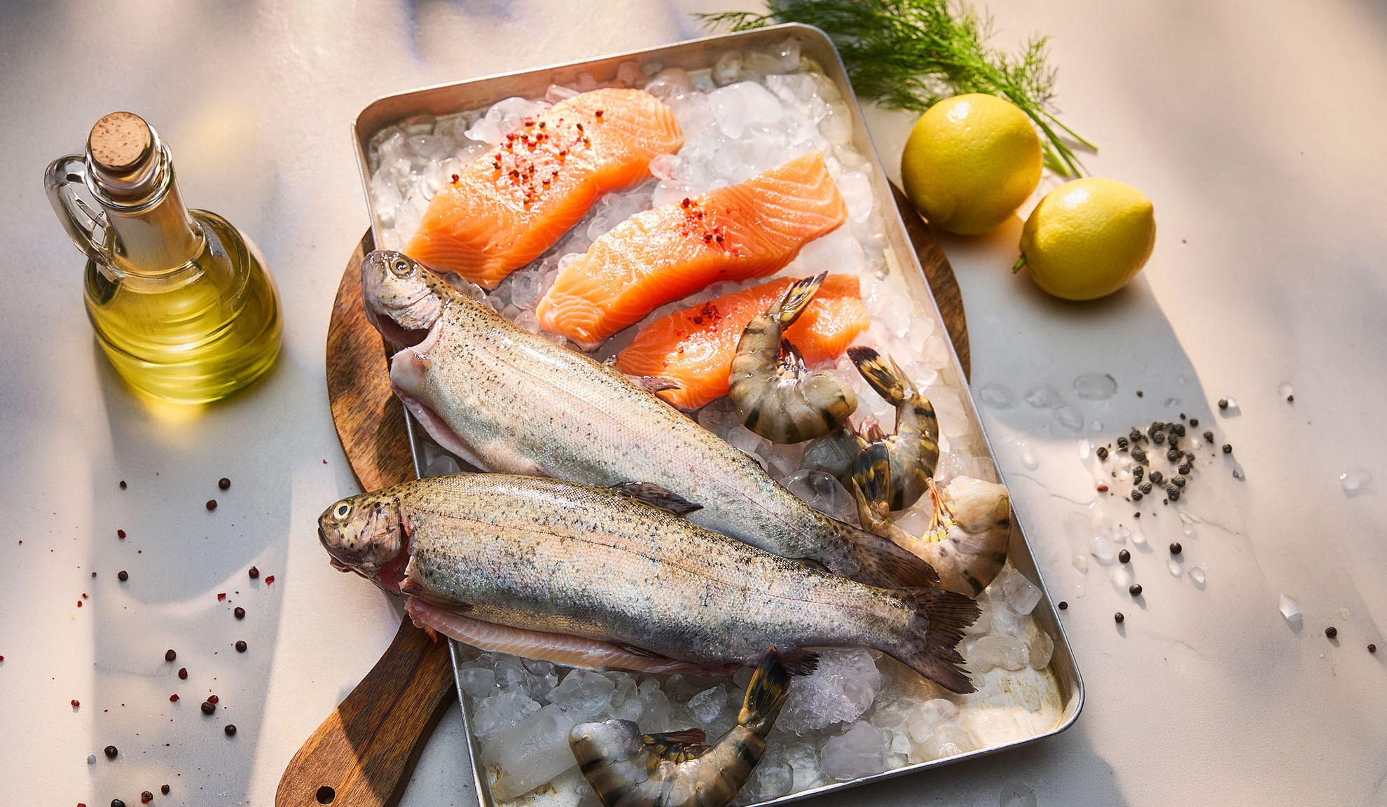 Peixe fresco, filetes de salmão e camarão no gelo, com limões e azeite.