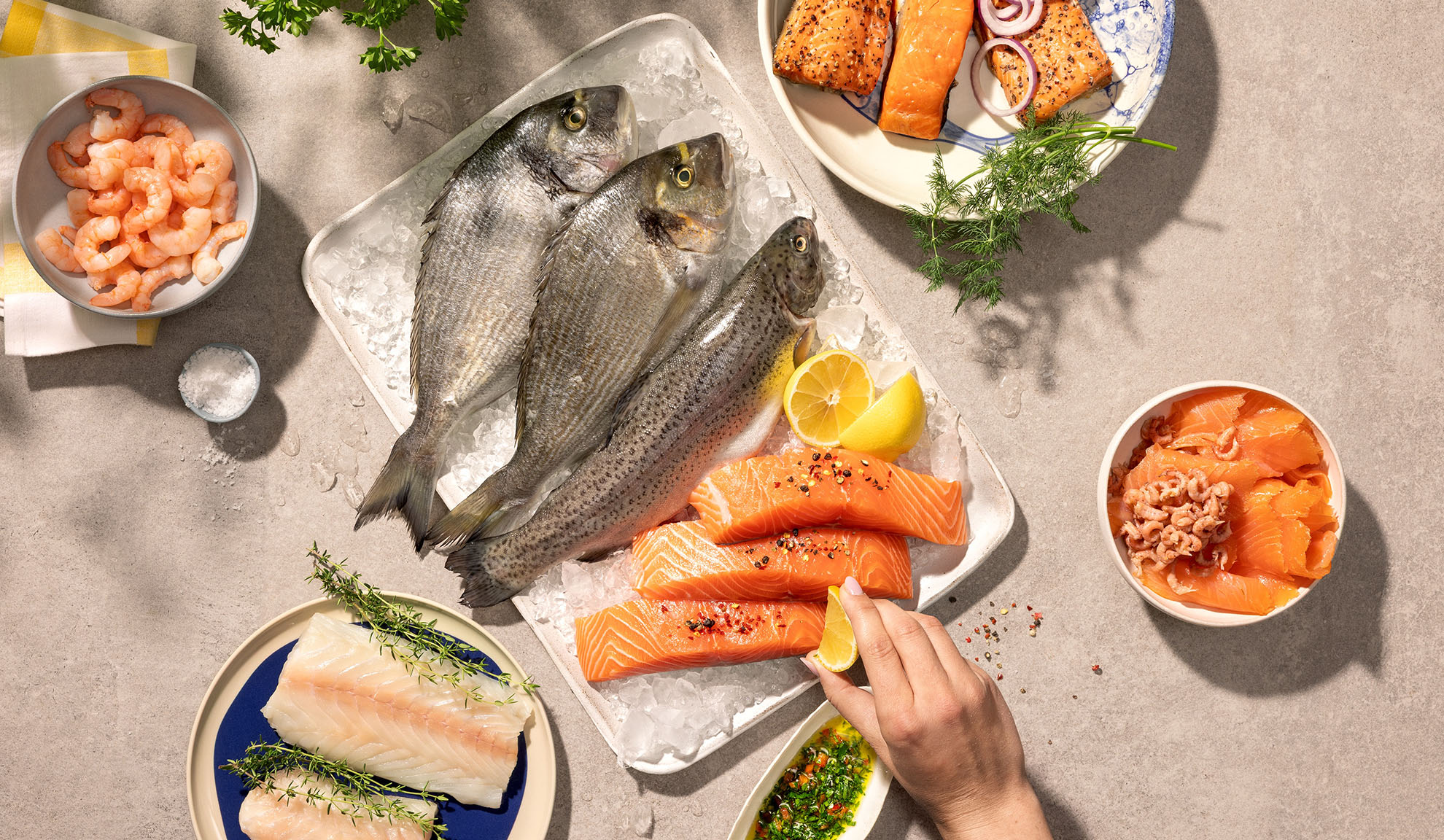 Variedade de marisco fresco, incluindo peixe, salmão e camarão, pronto a cozinhar.