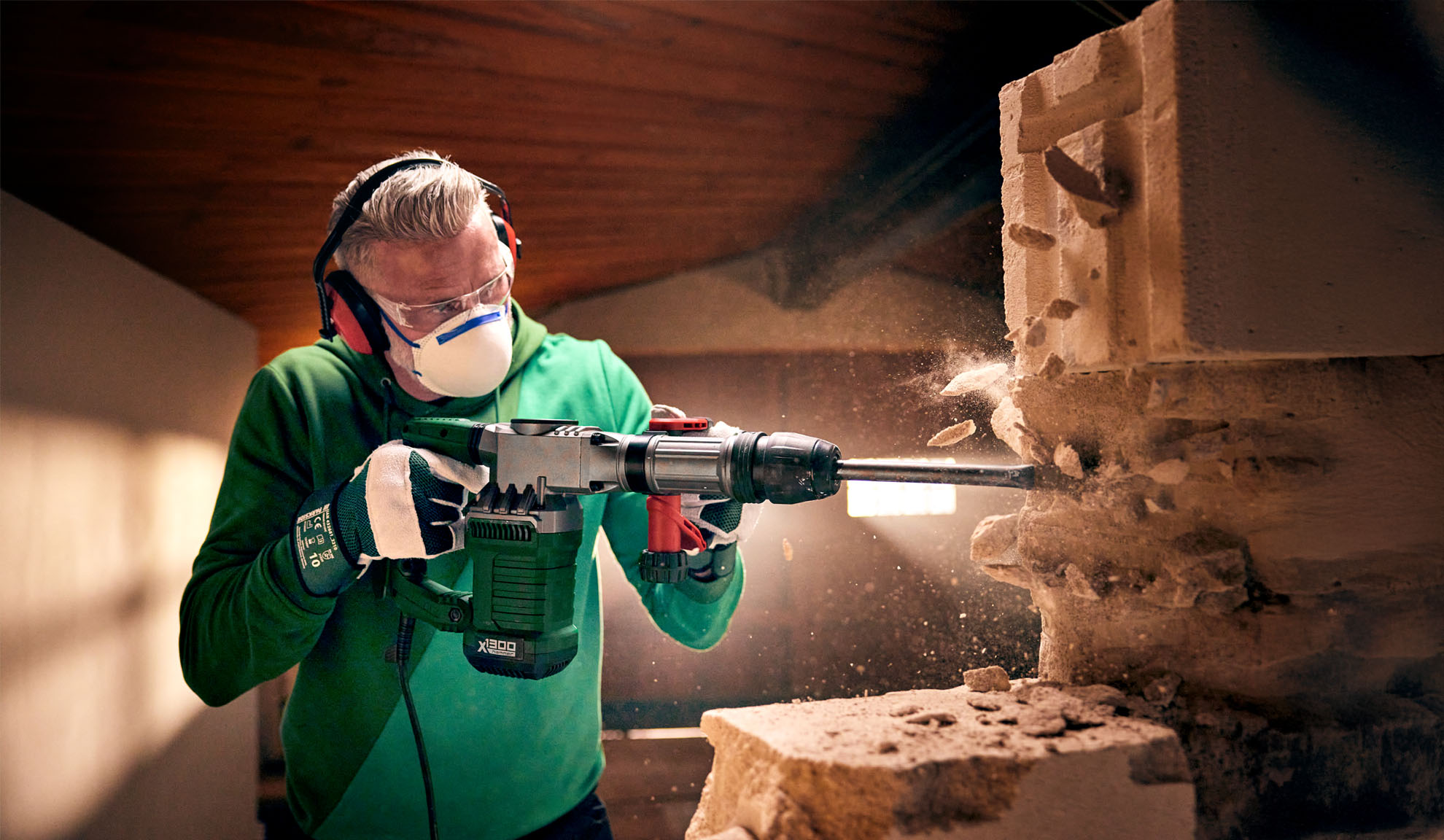 Um homem usa um martelo demolidor Worx X-BRUSHLESS para quebrar um bloco de concreto.