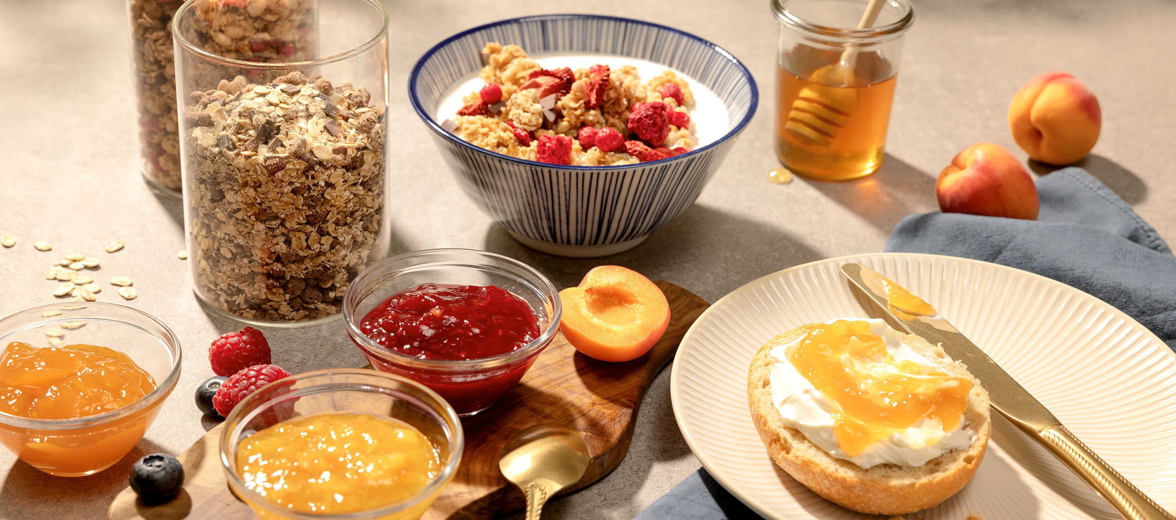 Pequeno-almoço com muesli, compota, mel e pão com queijo creme e compota.