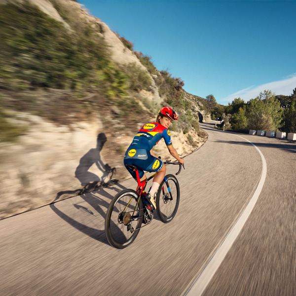 Ciclista em bicicleta de estrada em paisagem montanhosa.