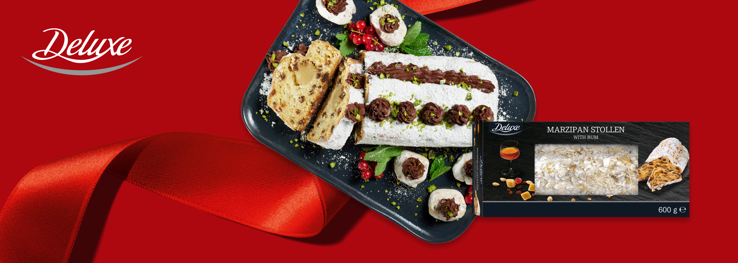 Deluxe Marzipan Stollen com rum, fatiado e decorado, com embalagem ao lado.