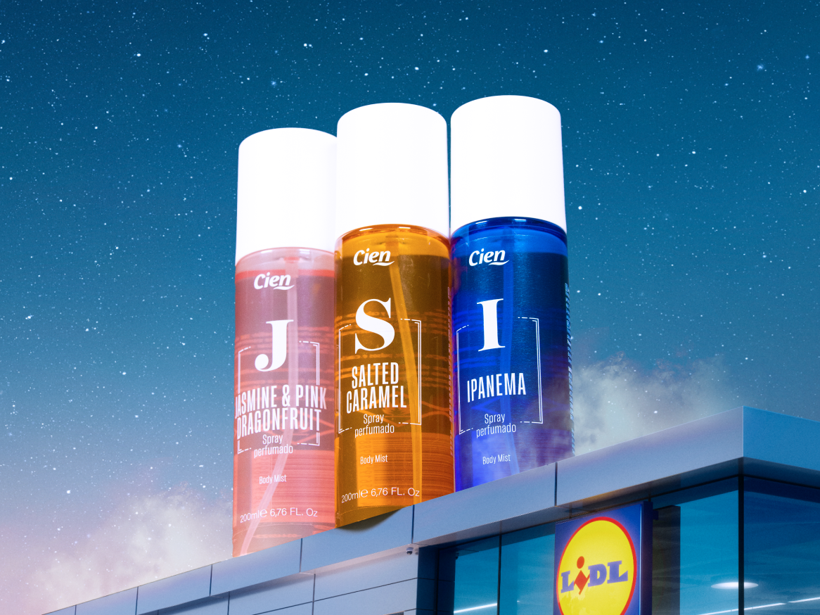 Três sprays corporais coloridos em cima de um edifício, com um céu estrelado ao fundo.