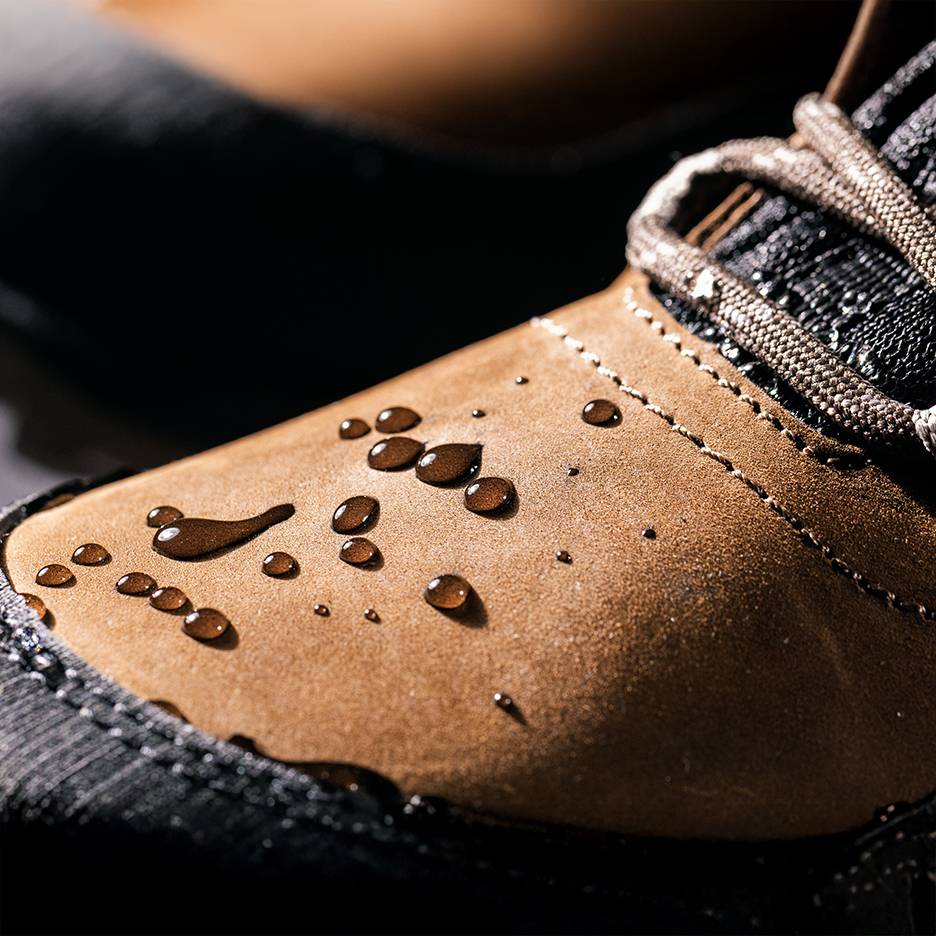 Sapatos castanhos impermeáveis com gotas de água na superfície.