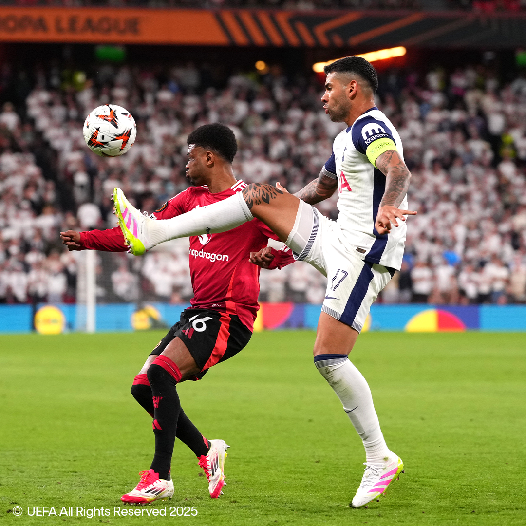 Dois jogadores de futebol com equipamentos Adidas e Nike disputam a bola em campo.