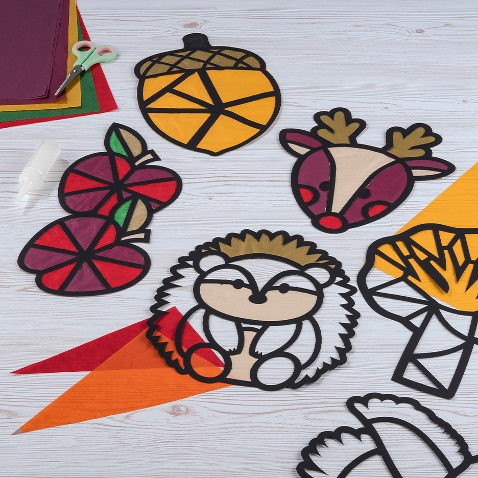 Decorações de outono feitas de papel colorido, incluindo uma bolota, um ouriço e um veado.