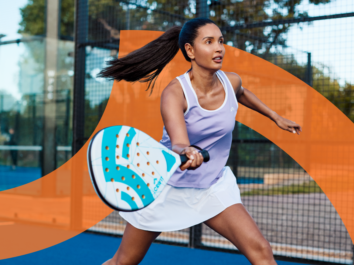 Mulher jogando padel com raquete Crivit em quadra azul.