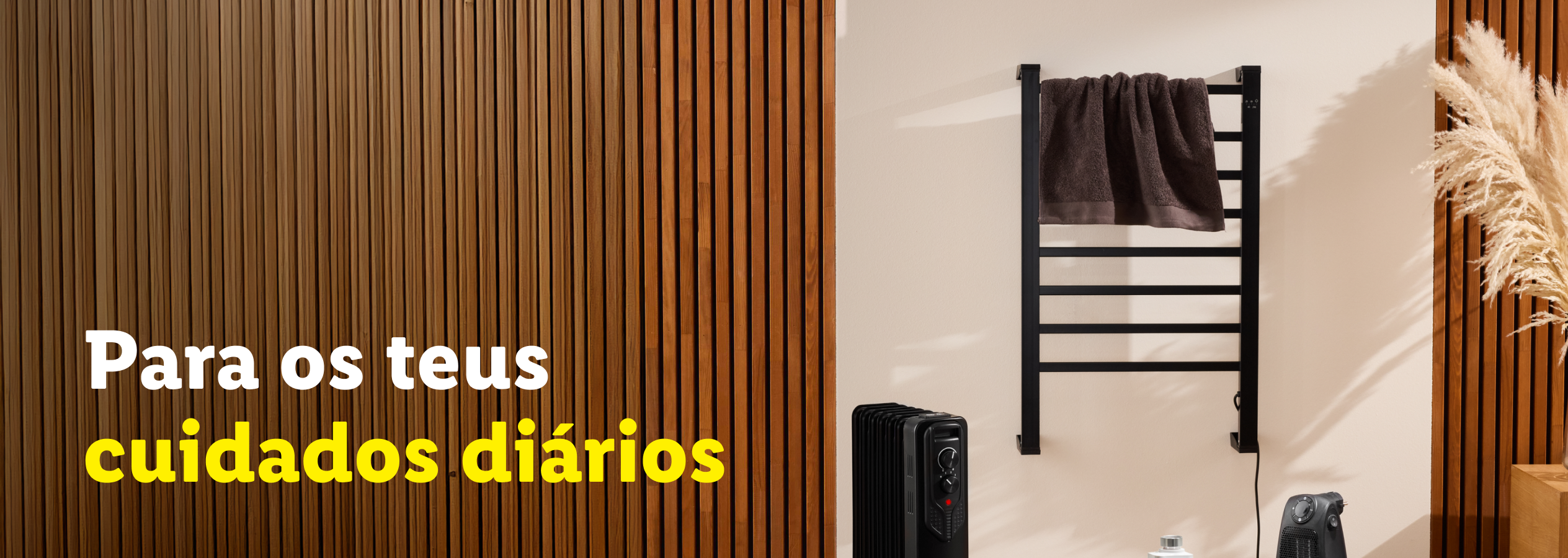 Toalheiro elétrico preto com toalha castanha, aquecedor e aquecedor de ventoinha. Texto: Para os teus cuidados diários.