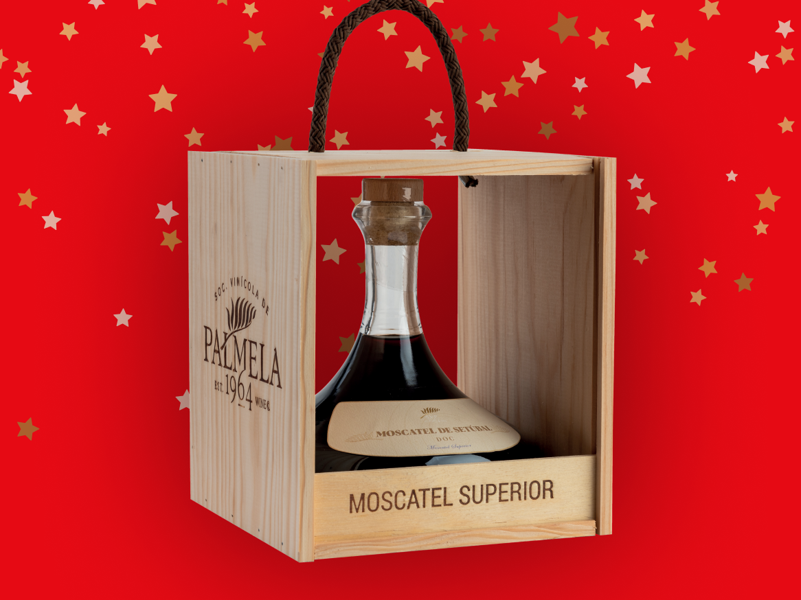 Garrafa de Moscatel de Setúbal Superior da Palmela numa caixa de madeira, sobre fundo vermelho com estrelas.