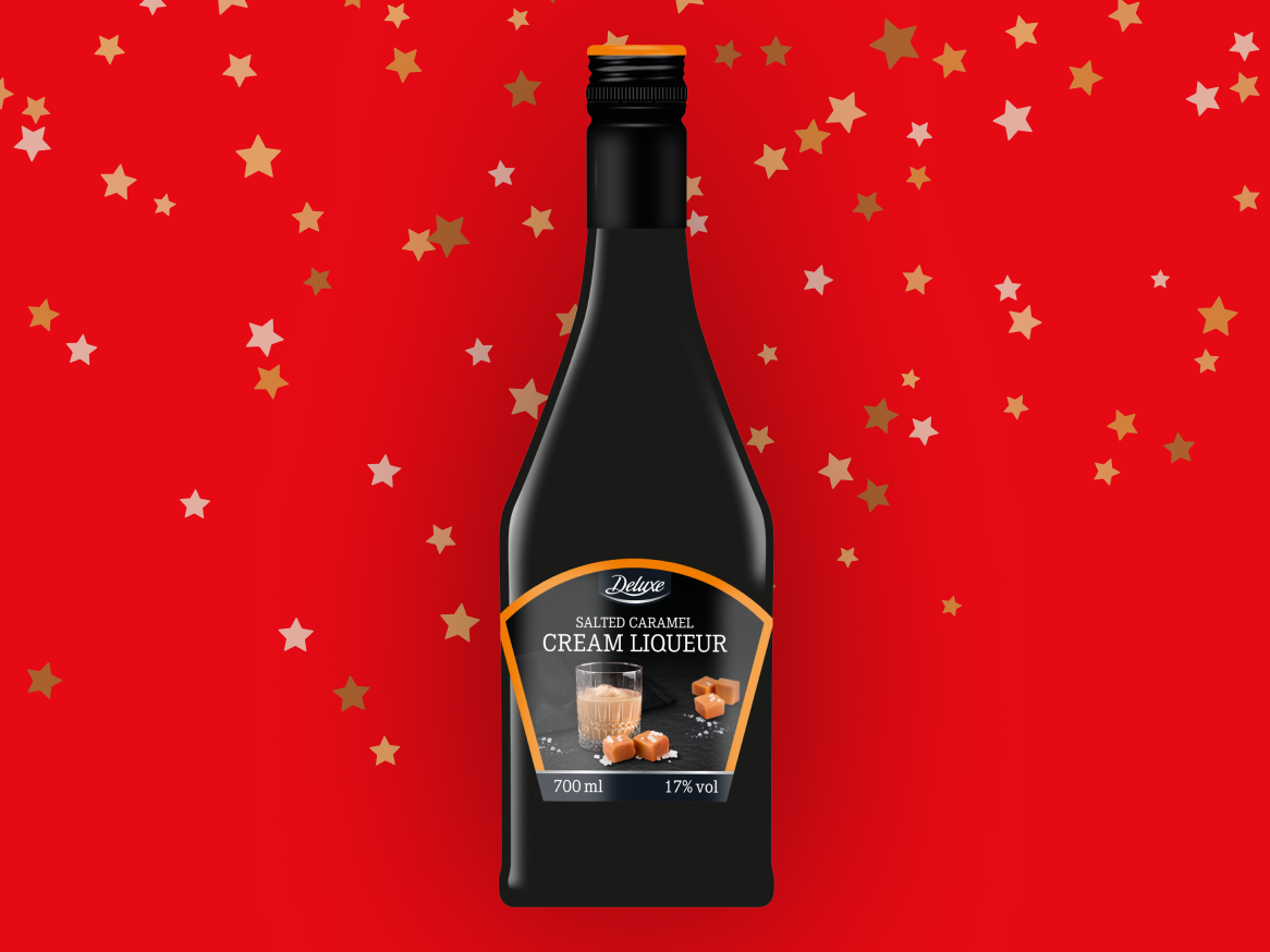 Garrafa de licor creme de caramelo salgado Deluxe em fundo vermelho com estrelas.