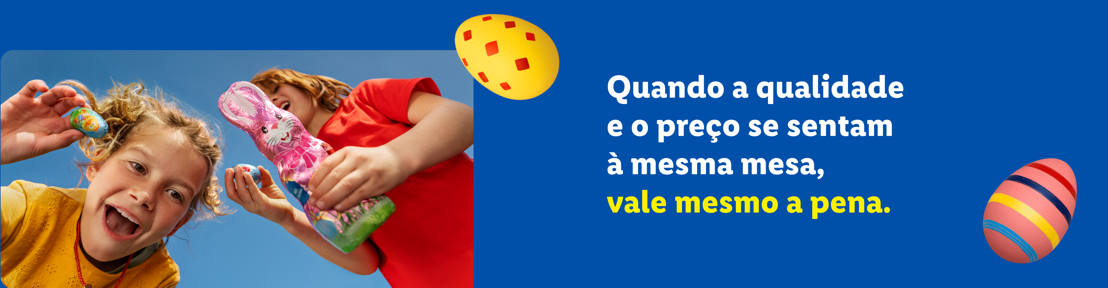 Duas crianças felizes com ovos de Páscoa e um coelho de chocolate, com o texto: 'Quando a qualidade e o preço se sentam à mesma mesa, vale mesmo a pena.'