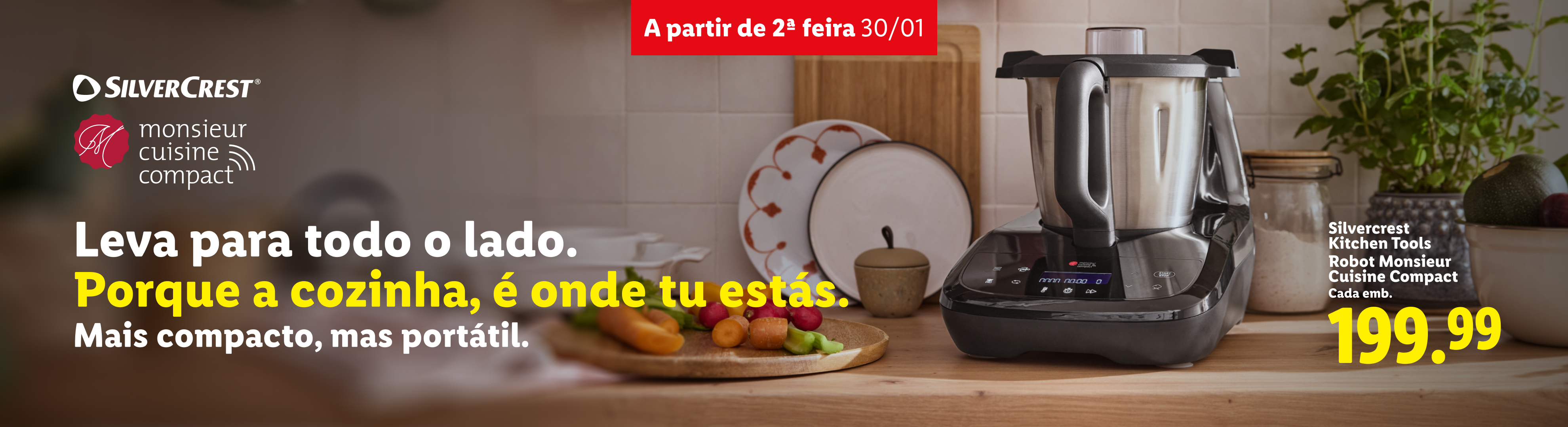 Um robot de cozinha compacto em cima de uma bancada de madeira com vegetais e pratos.