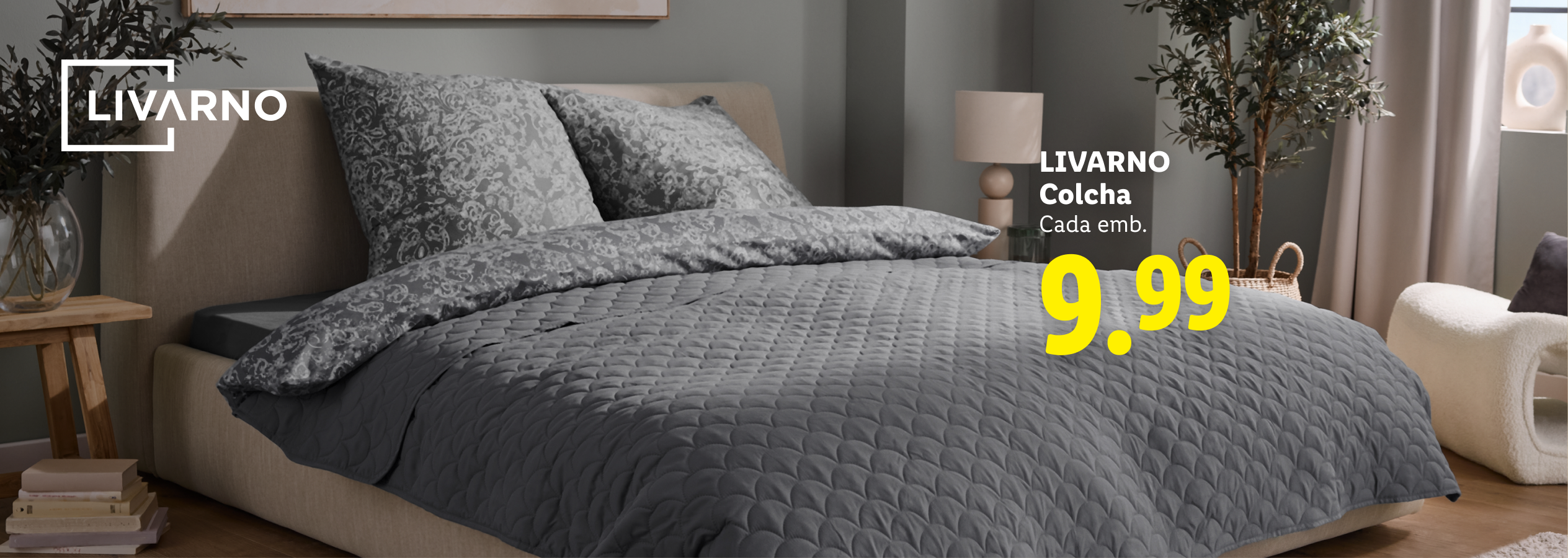Cama com colcha cinzenta e almofadas estampadas, preço 9,99.