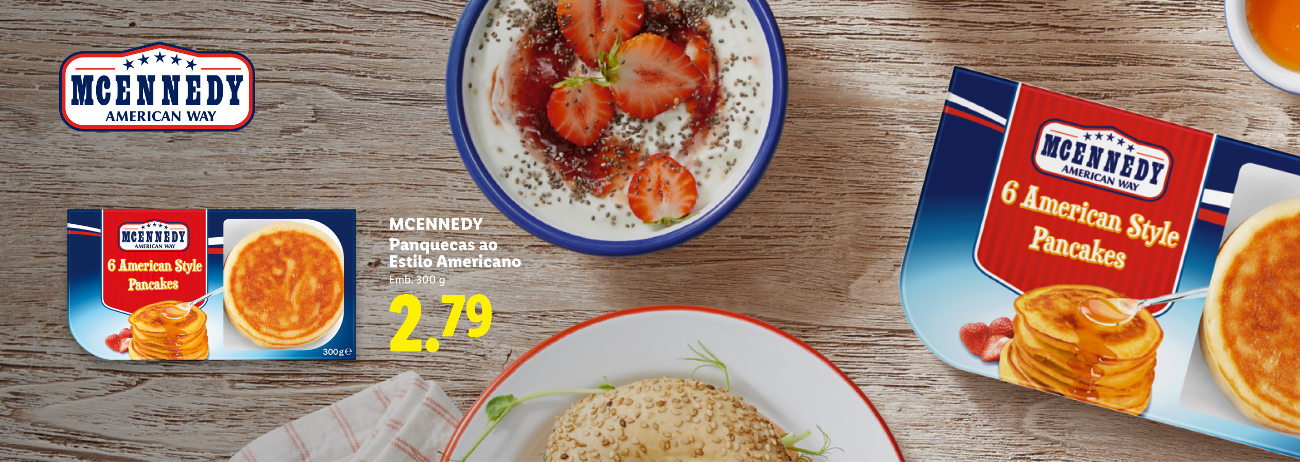 Panquecas estilo americano em embalagens e um prato com iogurte, morangos e sementes de chia.