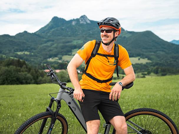 Bicicleta elétrica e ciclista em uma paisagem montanhosa.