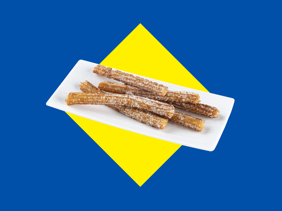 Churros açucarados num prato branco sobre um fundo azul e amarelo.