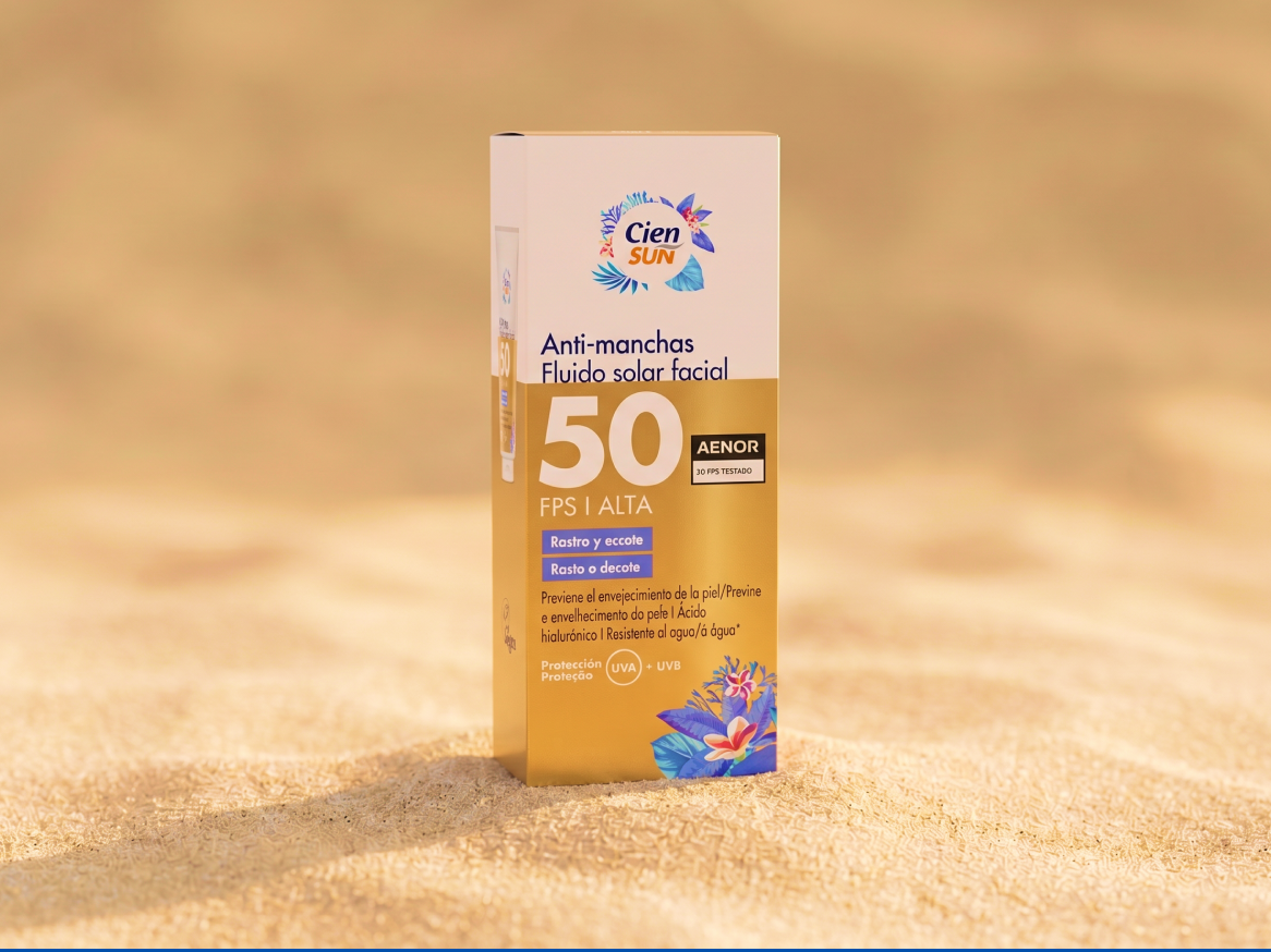 Protetor solar facial anti-manchas FPS 50 em caixa, sobre areia.